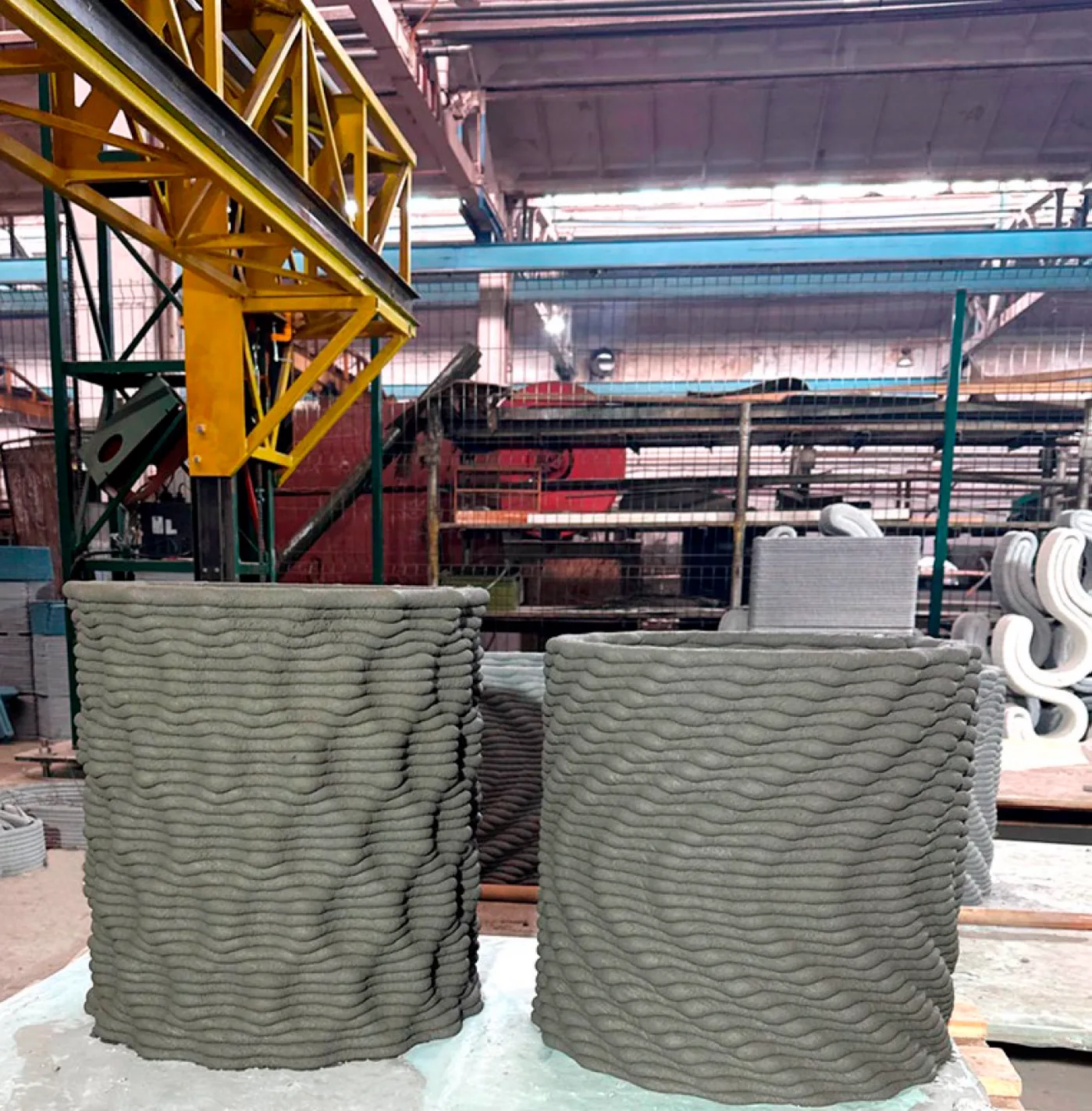 Two large concrete 3D-printed wall elements under a gantry